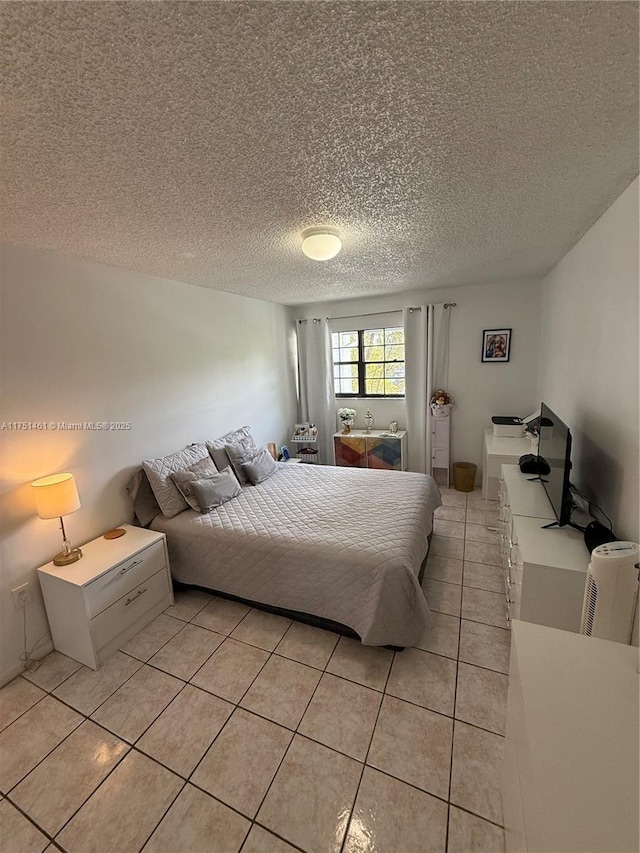 bedroom with light tile patterned floors and a textured ceiling