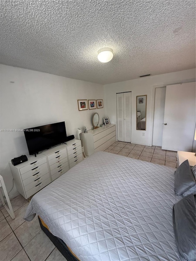 bedroom featuring light tile patterned flooring and a textured ceiling