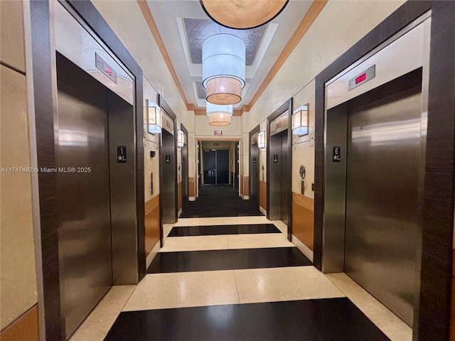 hall featuring tile patterned floors, elevator, and a tray ceiling
