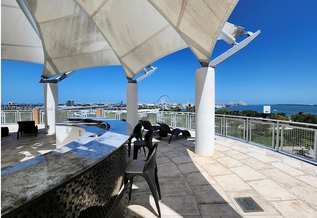 view of patio / terrace featuring visible vents, a water view, and outdoor dry bar