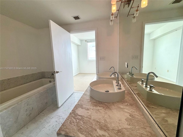 full bathroom featuring double vanity, a sink, a washtub, and visible vents