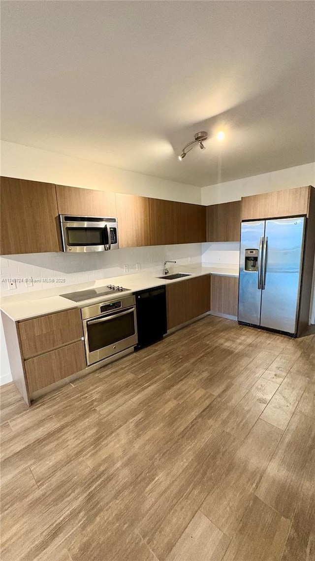1600 SW 1st Ave Unit 703, Miami, FL 33129 - kitchen featuring black appliances, modern cabinets, light countertops, light wood finished floors, and a sink