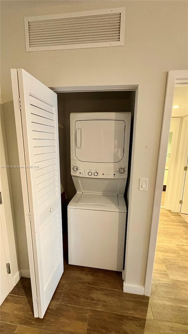 1600 SW 1st Ave Unit 703, Miami, FL 33129 - washroom featuring stacked washing machine and dryer, wood finished floors, and baseboards