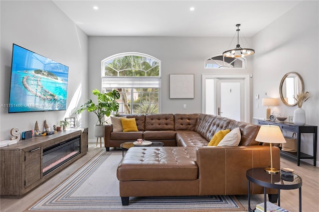 living area featuring light wood-type flooring, a glass covered fireplace, and recessed lighting