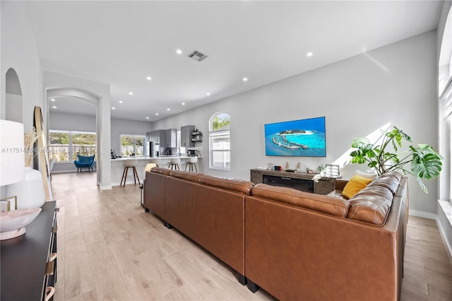 living area featuring baseboards, a wealth of natural light, and recessed lighting