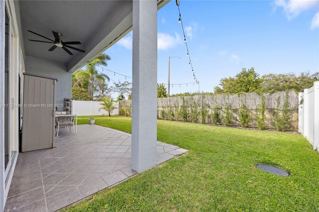 view of yard featuring a patio area, a fenced backyard, and a ceiling fan