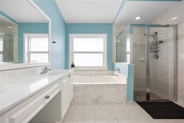 bathroom featuring tile patterned flooring, a healthy amount of sunlight, a garden tub, and a shower stall