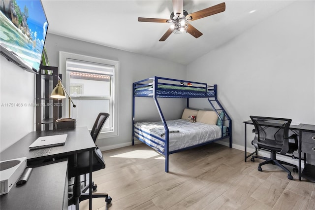 bedroom with lofted ceiling, light wood finished floors, a ceiling fan, and baseboards