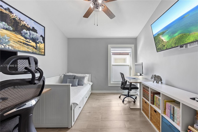 home office featuring light wood-style floors, baseboards, and a ceiling fan