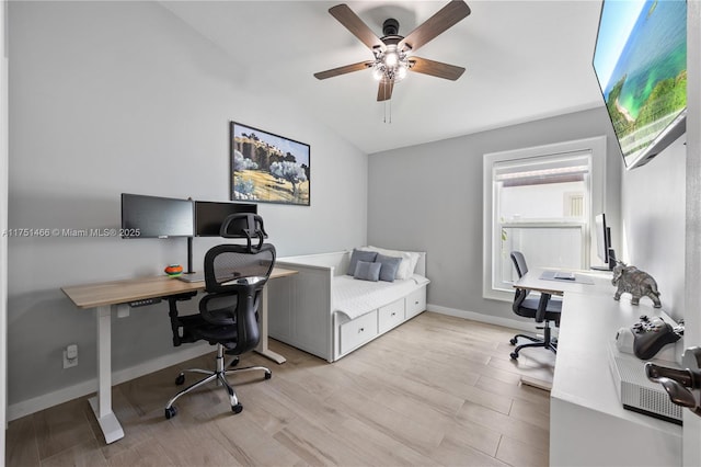 home office with light wood-type flooring, lofted ceiling, ceiling fan, and baseboards