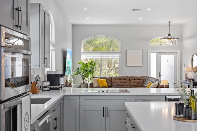 kitchen with gray cabinets, light countertops, and open floor plan