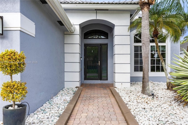 doorway to property featuring stucco siding