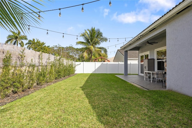 view of yard featuring ceiling fan, a patio area, and a fenced backyard