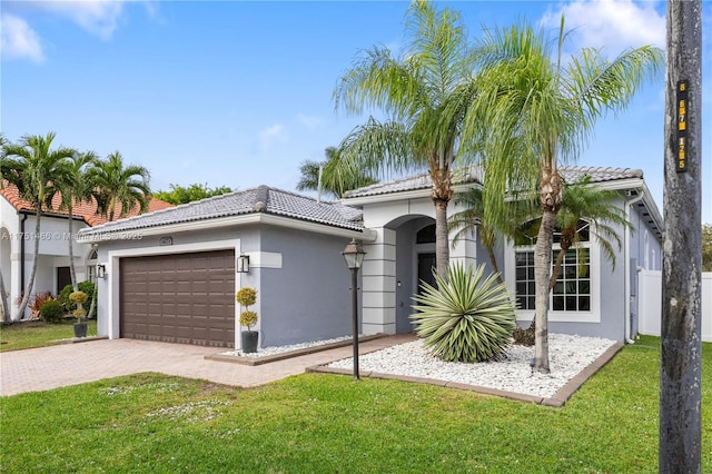 view of front of home with a garage, decorative driveway, a front lawn, and stucco siding