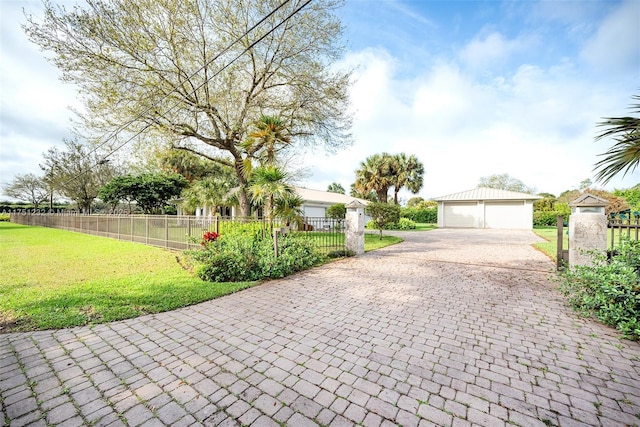 exterior space with a fenced front yard, a detached garage, and a front yard