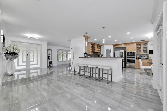 kitchen with appliances with stainless steel finishes, glass insert cabinets, decorative light fixtures, a peninsula, and french doors