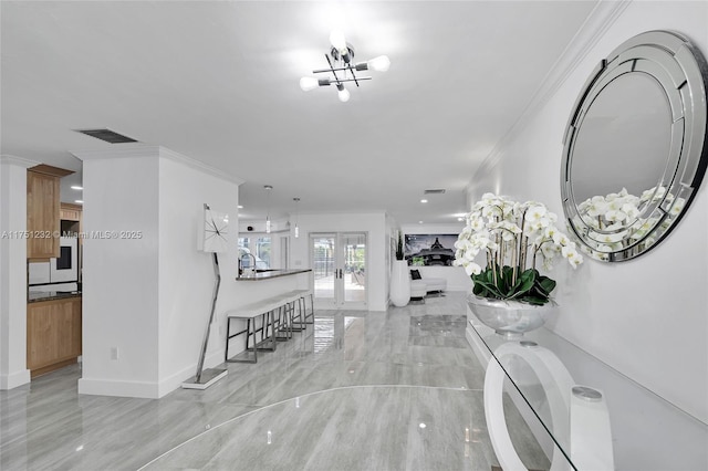 foyer featuring french doors, visible vents, and crown molding