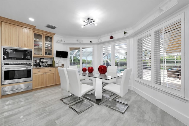 dining area featuring baseboards, visible vents, and crown molding