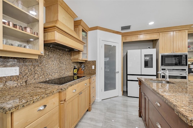 kitchen with glass insert cabinets, visible vents, light stone counters, and black appliances