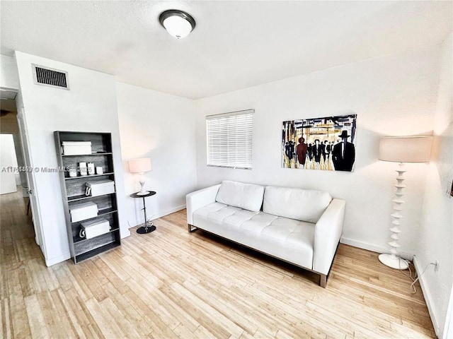 sitting room featuring light wood-style floors, baseboards, and visible vents