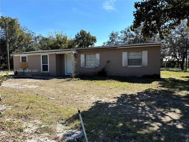 view of front of house featuring a front lawn and stucco siding