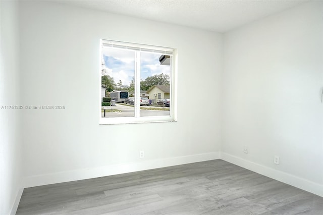empty room with wood finished floors and baseboards