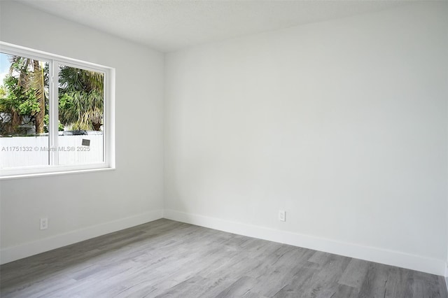 spare room with wood finished floors and baseboards