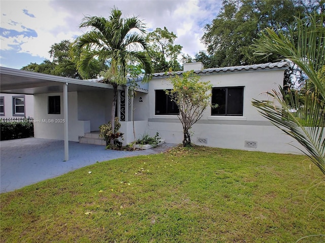 back of house with an attached carport, crawl space, a yard, and stucco siding