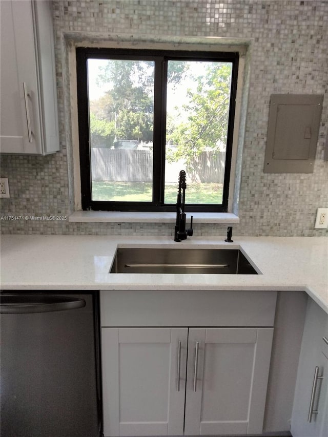 kitchen featuring backsplash, a sink, electric panel, plenty of natural light, and dishwasher