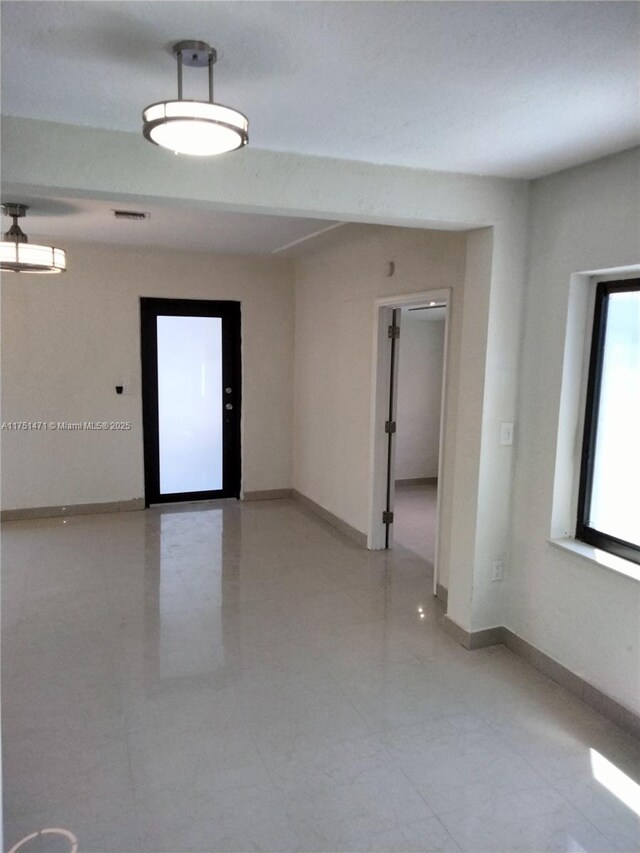 spare room featuring visible vents and baseboards