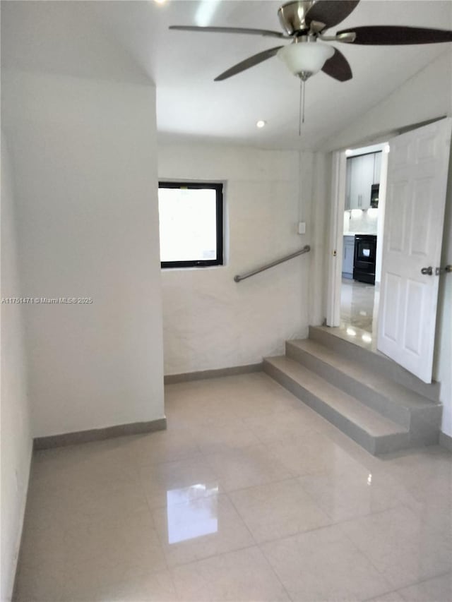 corridor featuring lofted ceiling and baseboards