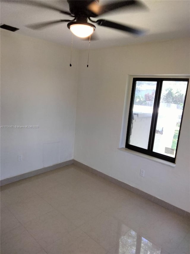 unfurnished room featuring ceiling fan, visible vents, and baseboards