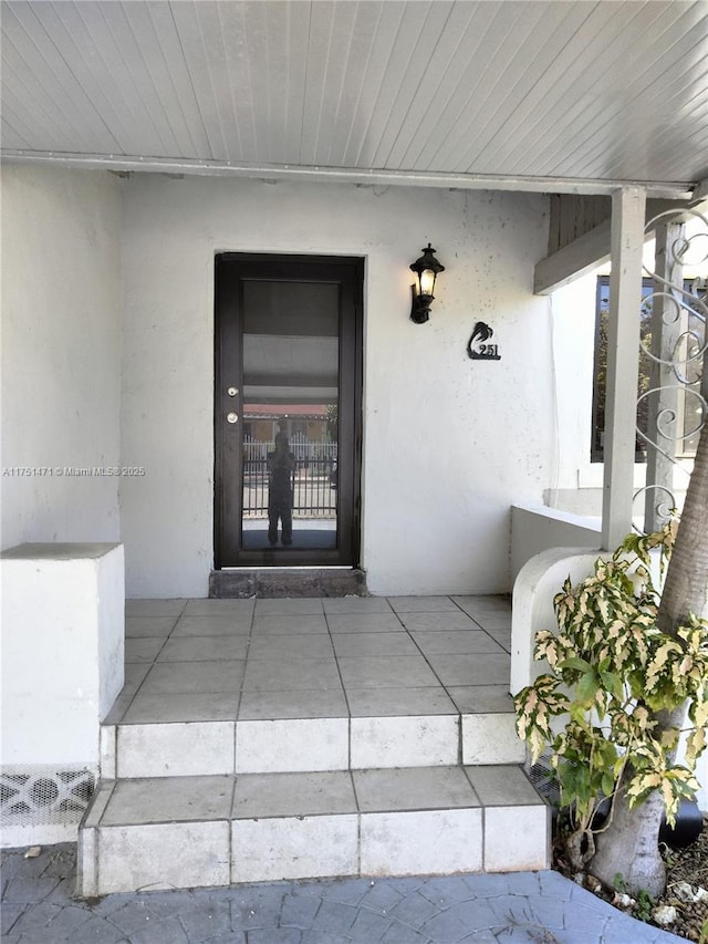 doorway to property featuring stucco siding