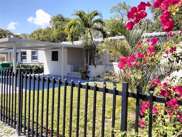 exterior space with a fenced front yard, a front lawn, and stucco siding