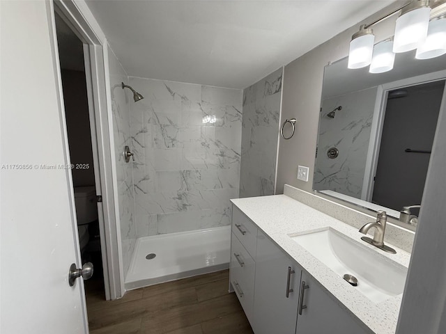 full bathroom with a stall shower, wood finished floors, and vanity