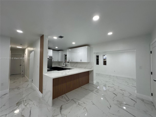 kitchen featuring recessed lighting, a peninsula, white cabinetry, marble finish floor, and light countertops