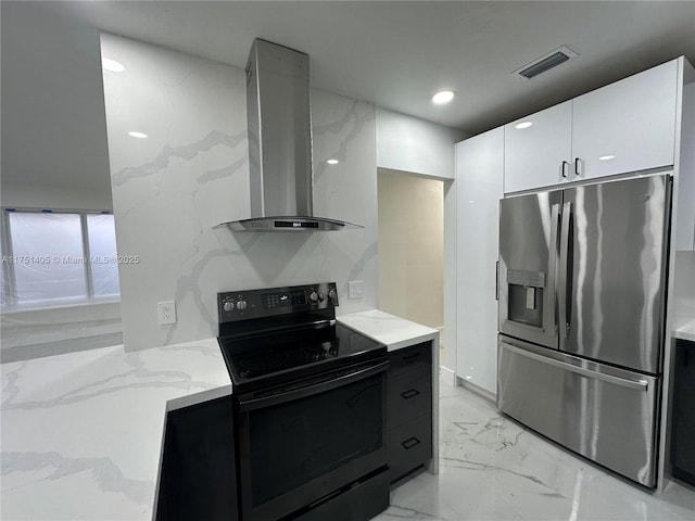 kitchen featuring black / electric stove, stainless steel refrigerator with ice dispenser, visible vents, white cabinetry, and wall chimney exhaust hood