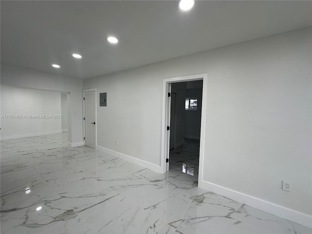 spare room featuring marble finish floor, electric panel, baseboards, and recessed lighting