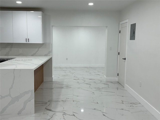 kitchen featuring marble finish floor, light stone counters, white cabinets, and recessed lighting