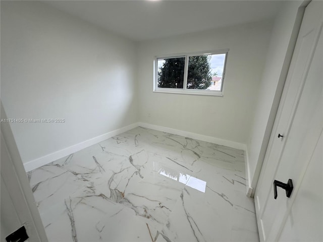 unfurnished bedroom featuring marble finish floor and baseboards