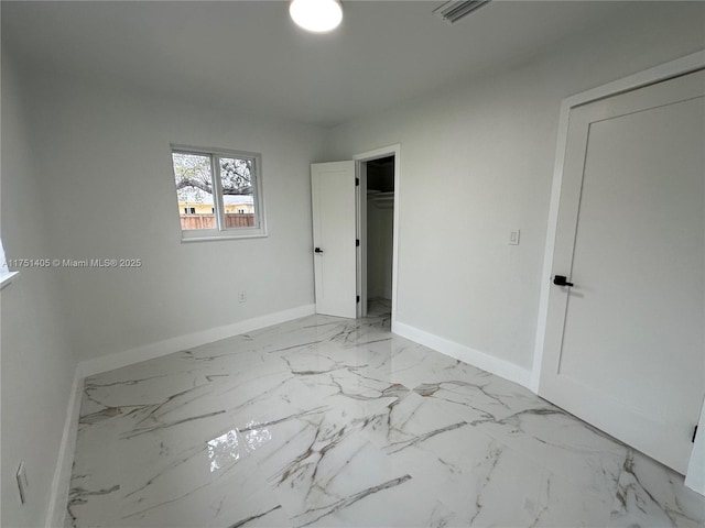 unfurnished bedroom featuring marble finish floor, visible vents, and baseboards