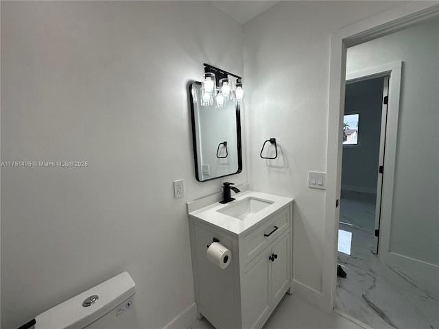 half bath featuring toilet, marble finish floor, baseboards, and vanity