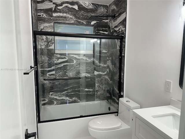 full bathroom featuring bath / shower combo with glass door, vanity, and toilet