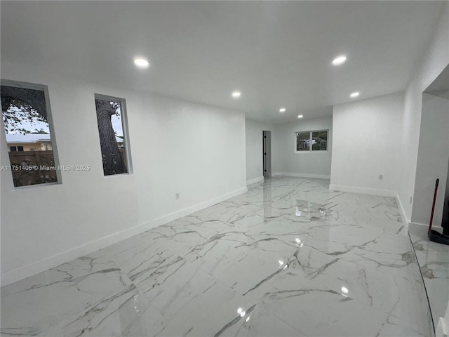 spare room featuring recessed lighting, marble finish floor, and baseboards