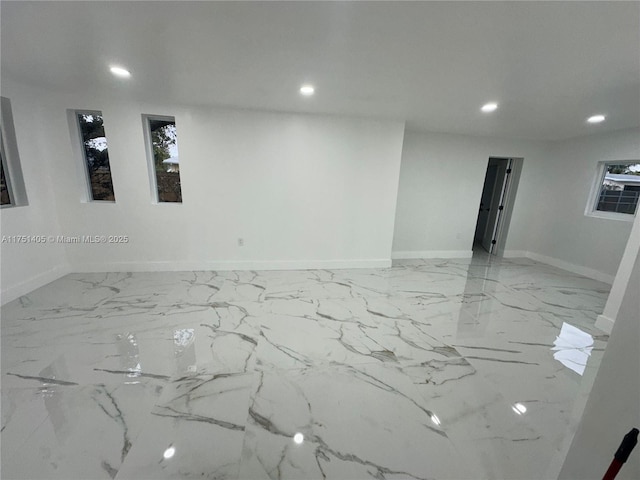 spare room with marble finish floor, baseboards, and recessed lighting