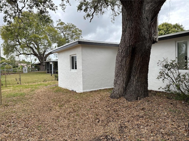 view of side of property with a lawn and stucco siding