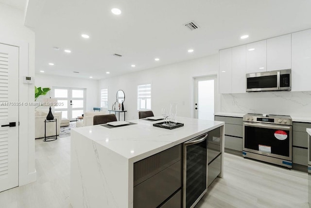 kitchen with wine cooler, visible vents, white cabinetry, appliances with stainless steel finishes, and modern cabinets