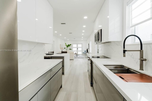 kitchen featuring white cabinetry, modern cabinets, appliances with stainless steel finishes, and a sink