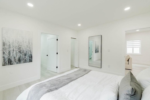 bedroom with baseboards, light wood-type flooring, and recessed lighting