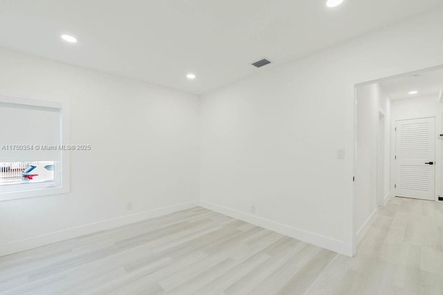 empty room with light wood finished floors, baseboards, visible vents, and recessed lighting